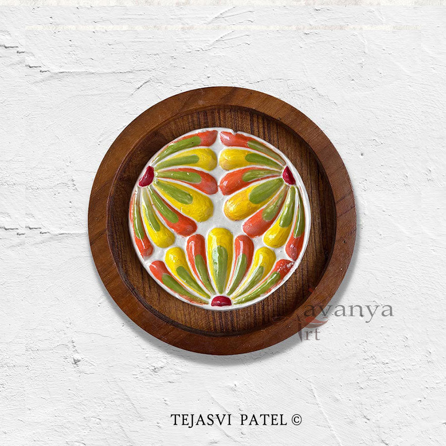 Handmade ceramic wall sculpture inspired by flower from Tejasvi Patel. Lavanya Art Studio creates textured art framed in beautiful teak wood.