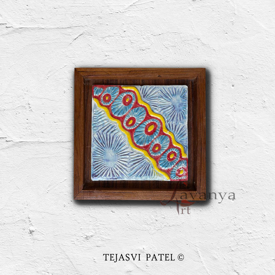 Discover handmade ceramic wall sculptures by Indian artist Tejasvi Patel at Lavanya Art Studio, featuring textured art and elegant teak wood frames.